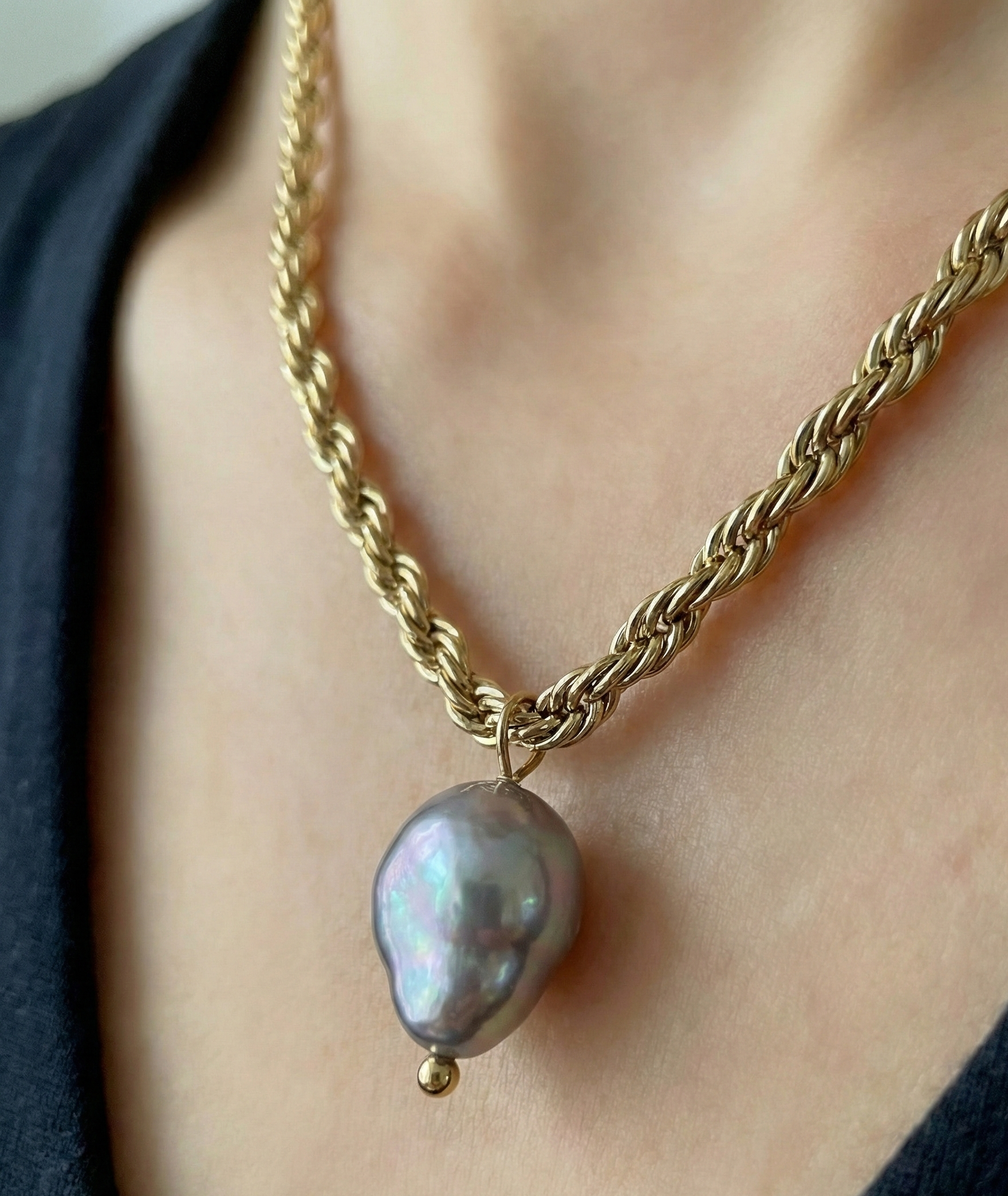Featuring a bold, architectural rope chain, this piece serves as the perfect pedestal for a single, magnificent AAA-grade grey baroque pearl.