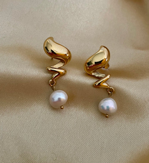 Close-up detail of the light-reflecting gold texture on Alizee earrings paired with a high-lustre AAA freshwater pearl
