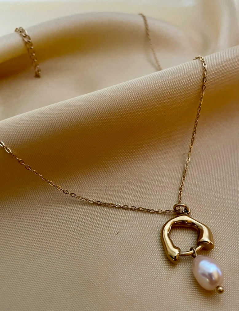 dainty gold chain necklace with a sculptural molten gold charm and a single freshwater pearl drop in soft pink