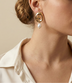 Close-up of a model wearing a vintage french style 18k gold earring with cultured pearl drop on a neutral background