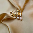 unique, organic-shaped gold earrings featuring lustrous pink oval pearl drops