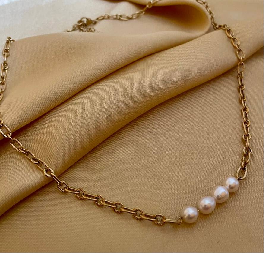 Close-up of gold link necklace featuring four high-luster oval white pearls