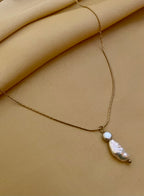 delicate gold chain necklace featuring a stacked pendant with a lustrous white keshi pearl and a small grey baroque pearl