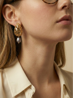 Close-up detail of luxury gold lattice teardrop earrings featuring a suspended metallic grey pearl with high chrome luster
