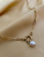 gold paperclip chain necklace featuring a lustrous white baroque pearl pendant and a circular front toggle clasp