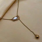 Gold necklace with a pendant on a beige fabric background