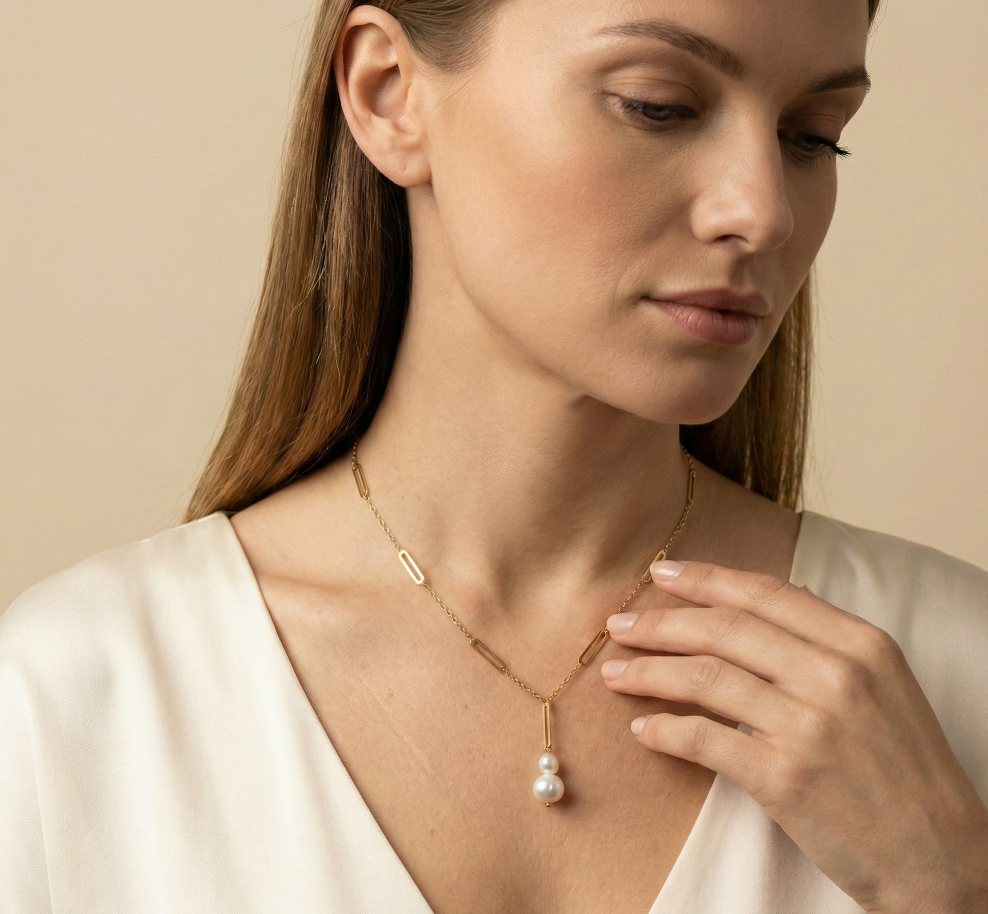 Elegant gold lariat style necklace with genuine freshwater baroque pearls. Minimalist bridal jewelry on a female model, highlighting high-luster pearl drop and modern gold link chain design