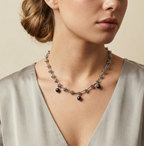 Close-up of a modern silver chain necklace with black pearls on a model i