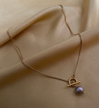 gold double-strand lariat necklace featuring a lustrous grey baroque pearl and toggle clasp