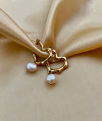 jewelry styling inspiration featuring melted gold texture earrings with pearls. Minimalist bridal jewelry and statement gold hoops for a clean, elegant aesthetic.