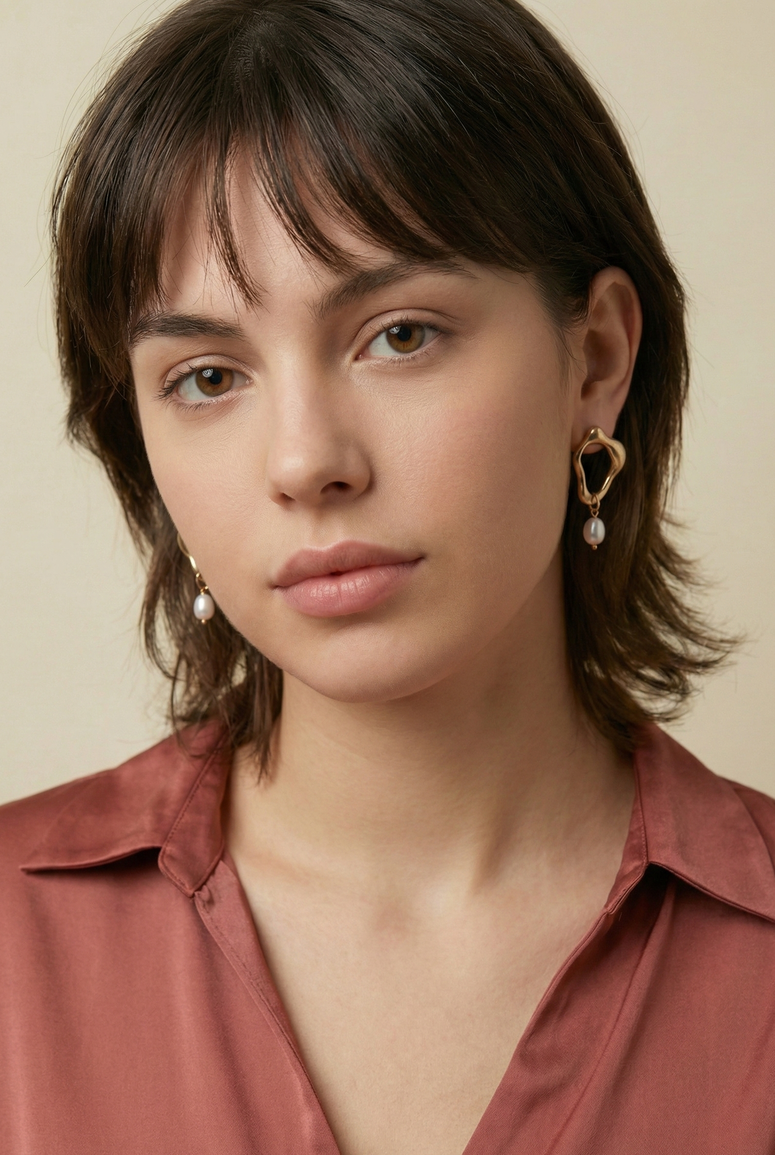 woman wearing sculptural gold earrings with a delicate freshwater pearl drop, ideal for weddings, office and casual night outs