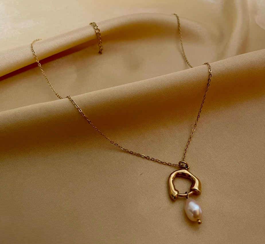 gold organic open-circle pendant necklace featuring a suspended lustrous champagne-pink oval pearl